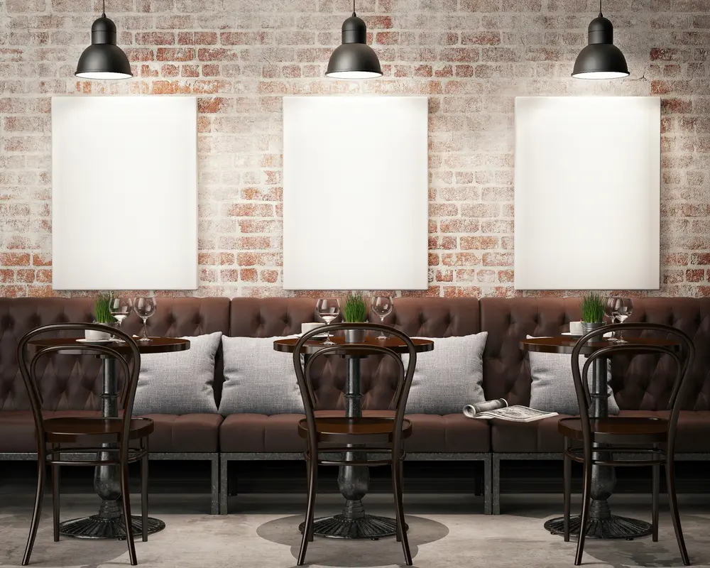 Restaurant seating with overhead lighting and blank posters